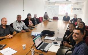 Participantes sentados à mesa de reunião