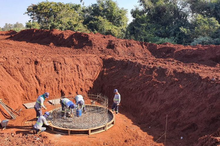 Operários da SANEPAR em obra num espaço parecido com um aterro com muita terra avermelhada - estação de tratamento de esgoto